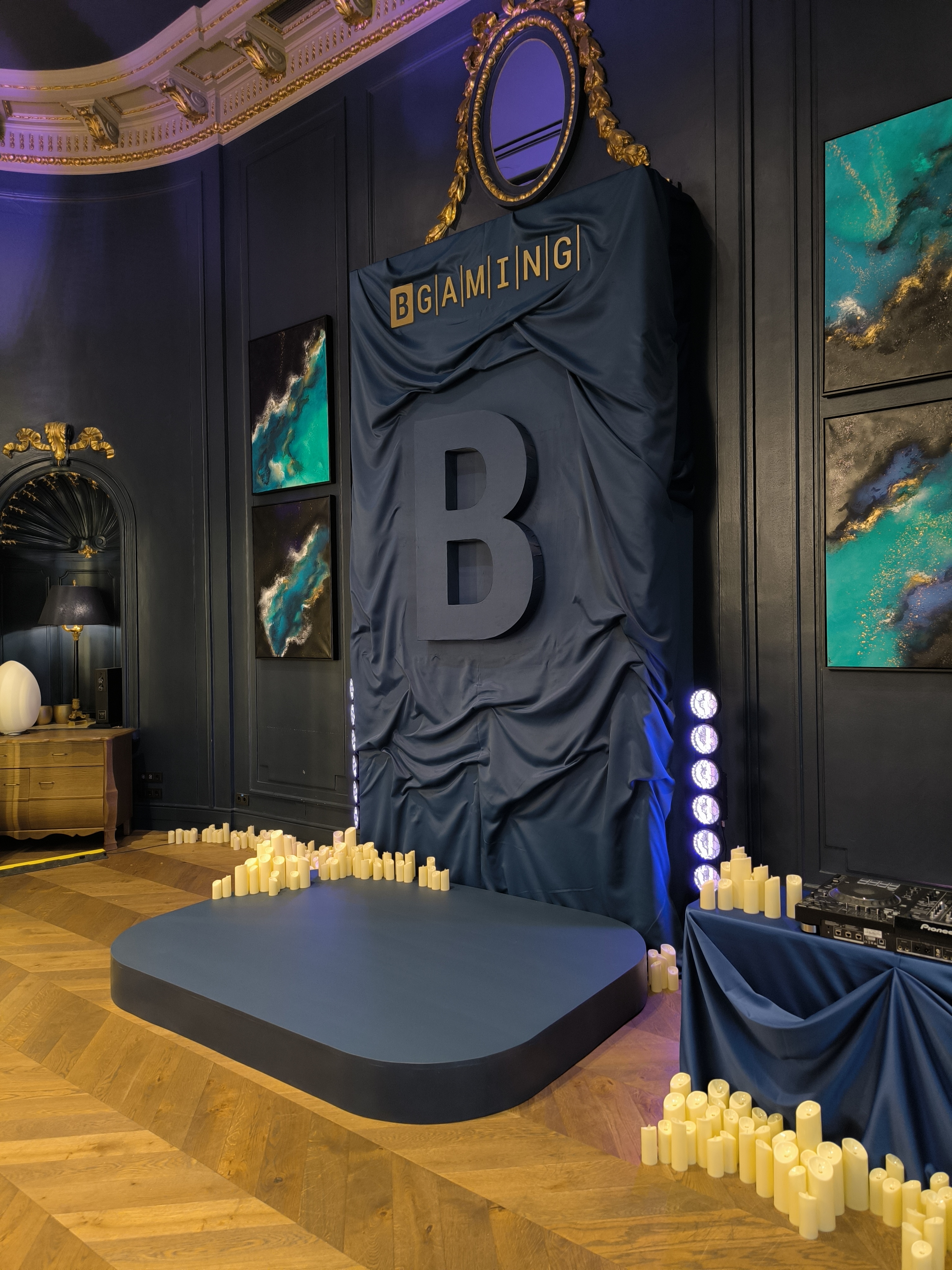 Photocall exclusivo de la marca BGaming con letra corpórea grande, cortinas y velas